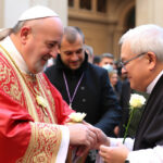 ALT: "Papa Leone XIV omaggia Papa Francesco con una rosa bianca dopo la visita a Genazzano, simbolo di rispetto e continuità nella fede."